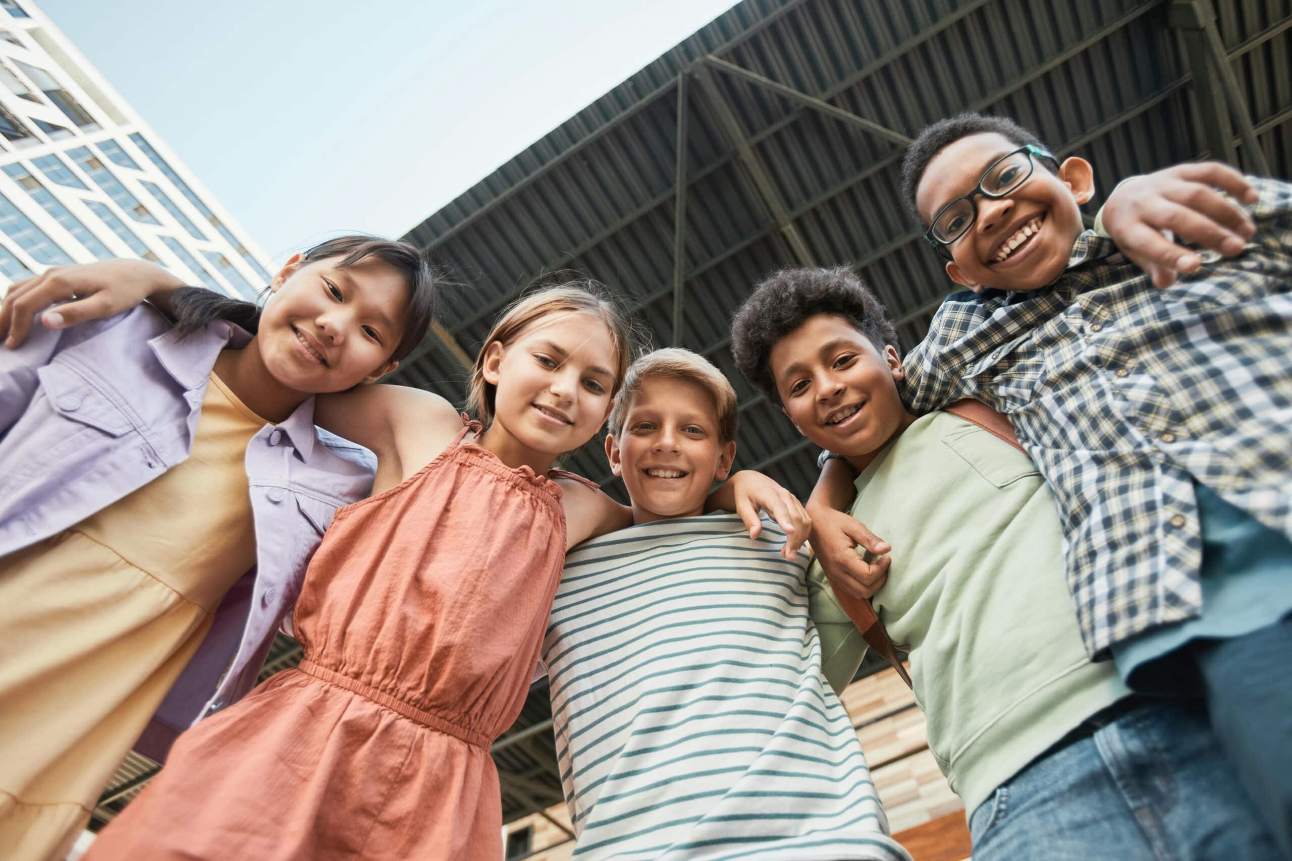 Group of smiling girls and boys with around around each other
