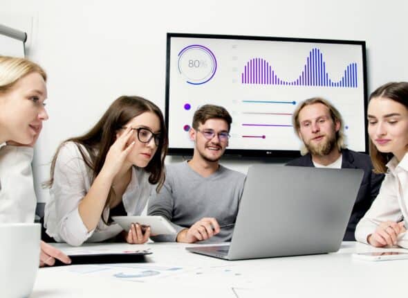 Group of young employees smiling and looking at laptop.
